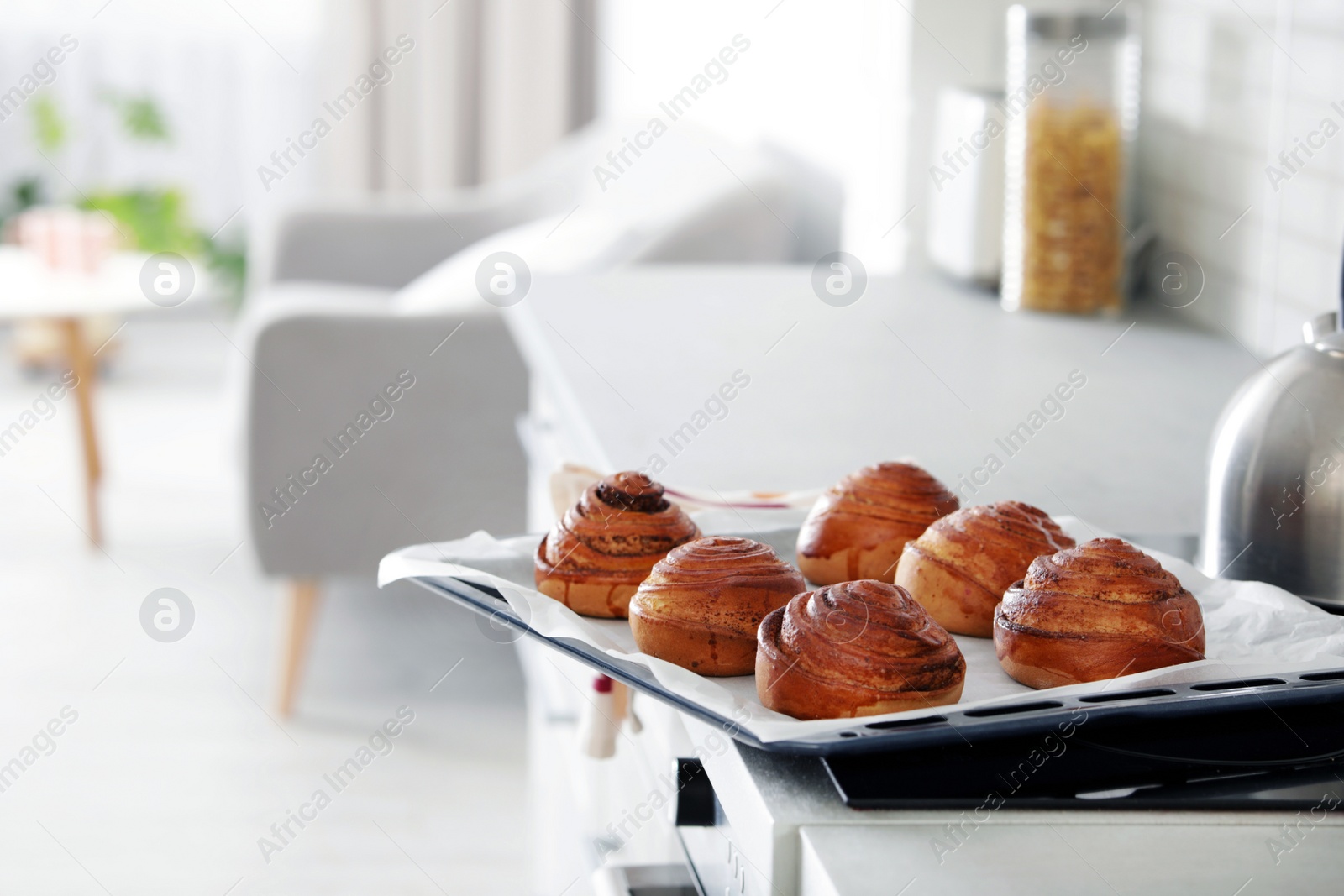 Photo of Tray with freshly oven baked buns on stove in kitchen. Space for text