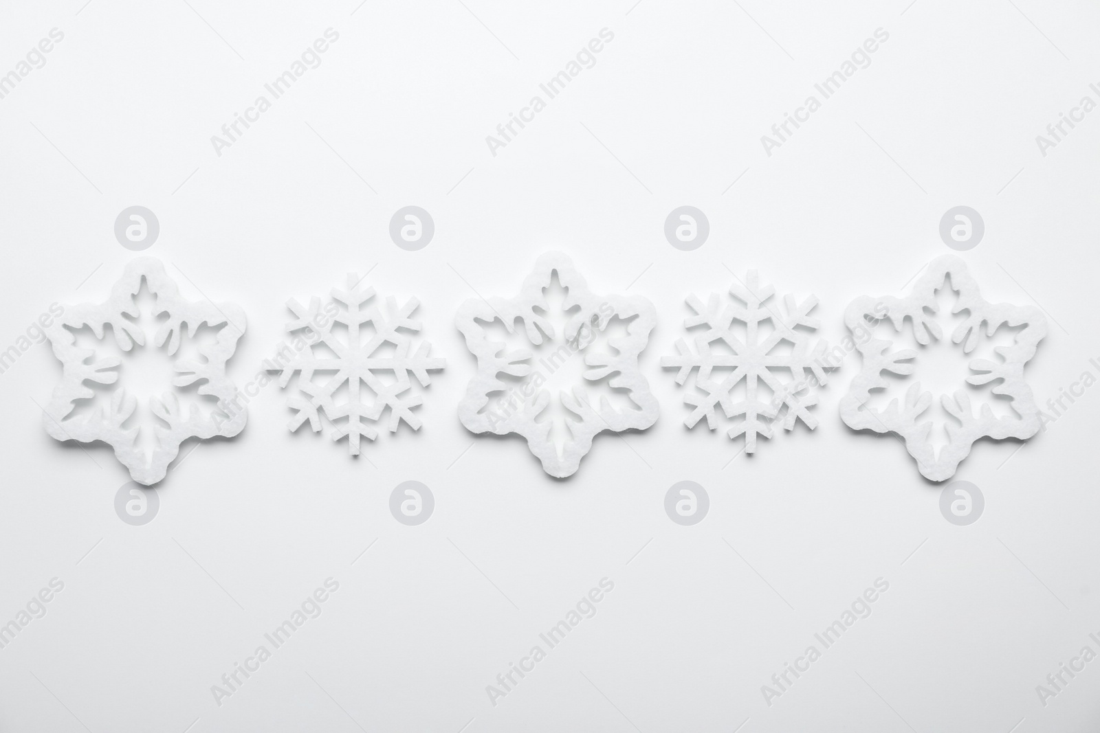 Photo of Beautiful decorative snowflakes on white background, flat lay