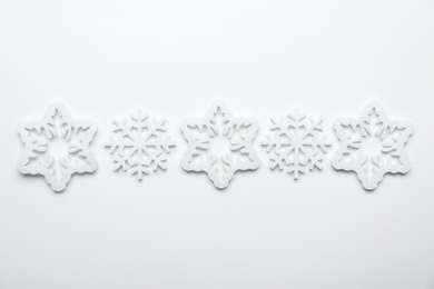 Beautiful decorative snowflakes on white background, flat lay