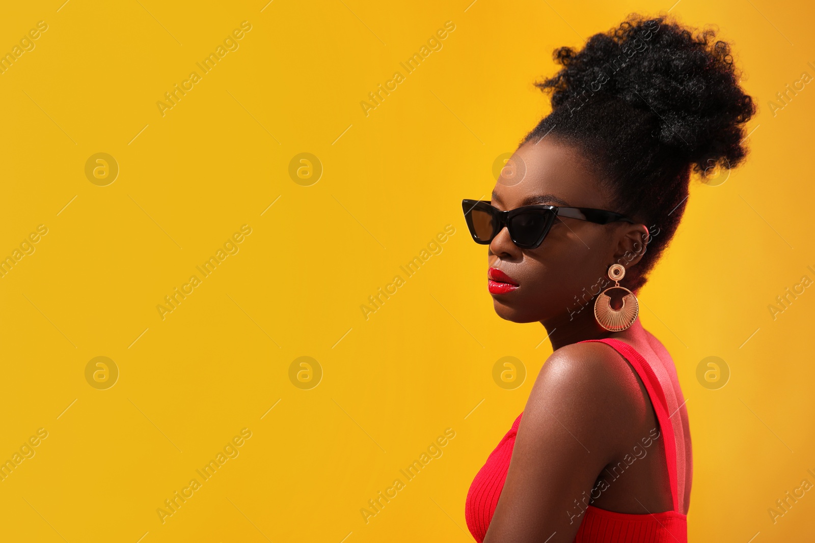 Photo of Fashionable portrait of beautiful woman with stylish sunglasses on yellow background, space for text