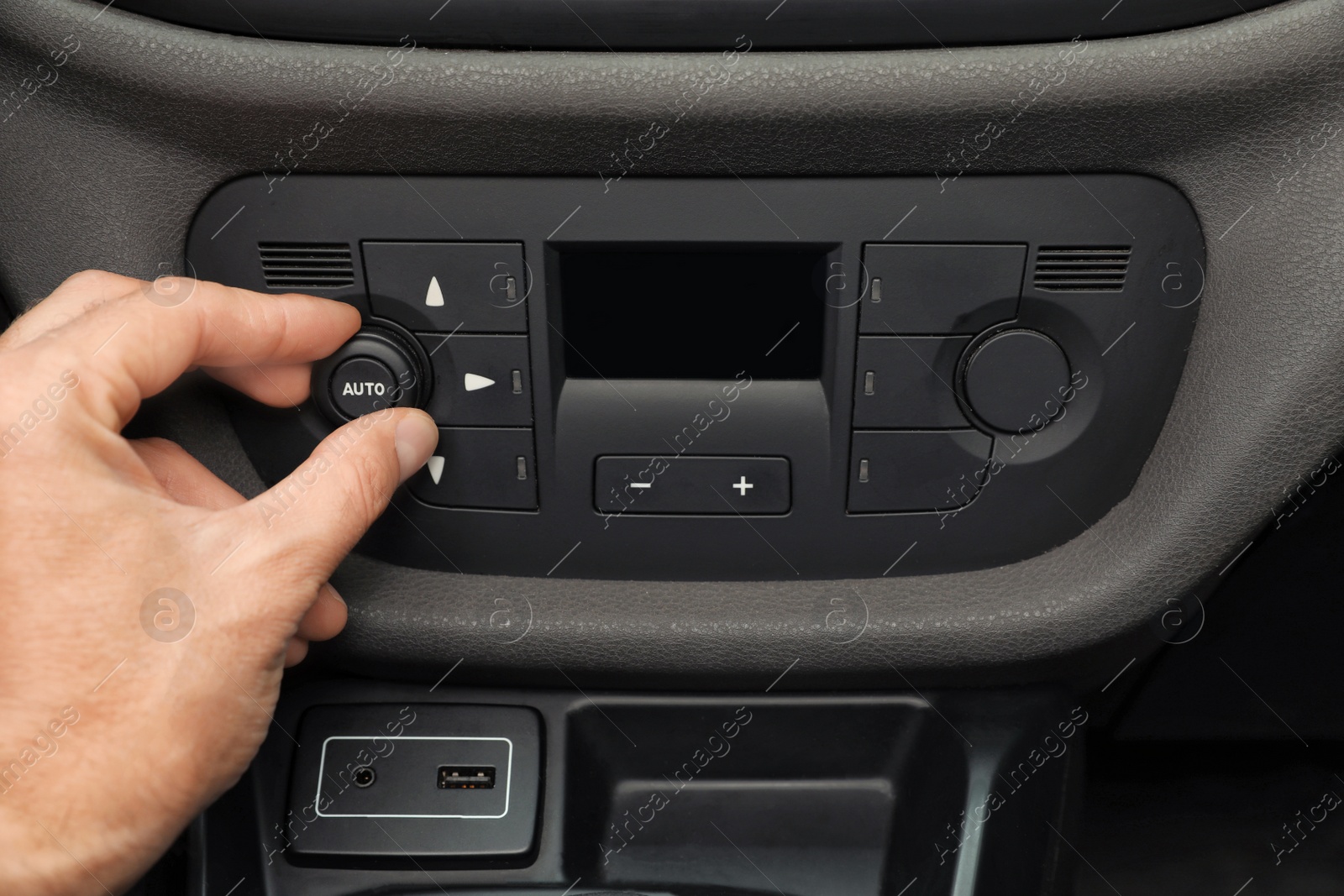 Photo of Man adjusting air conditioner in car, closeup