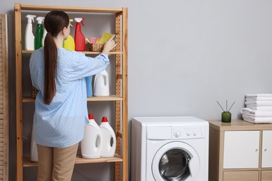 Woman taking cleaning cloth from basket in laundry room