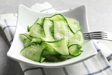 Photo of Plate with delicious cucumber salad served on table