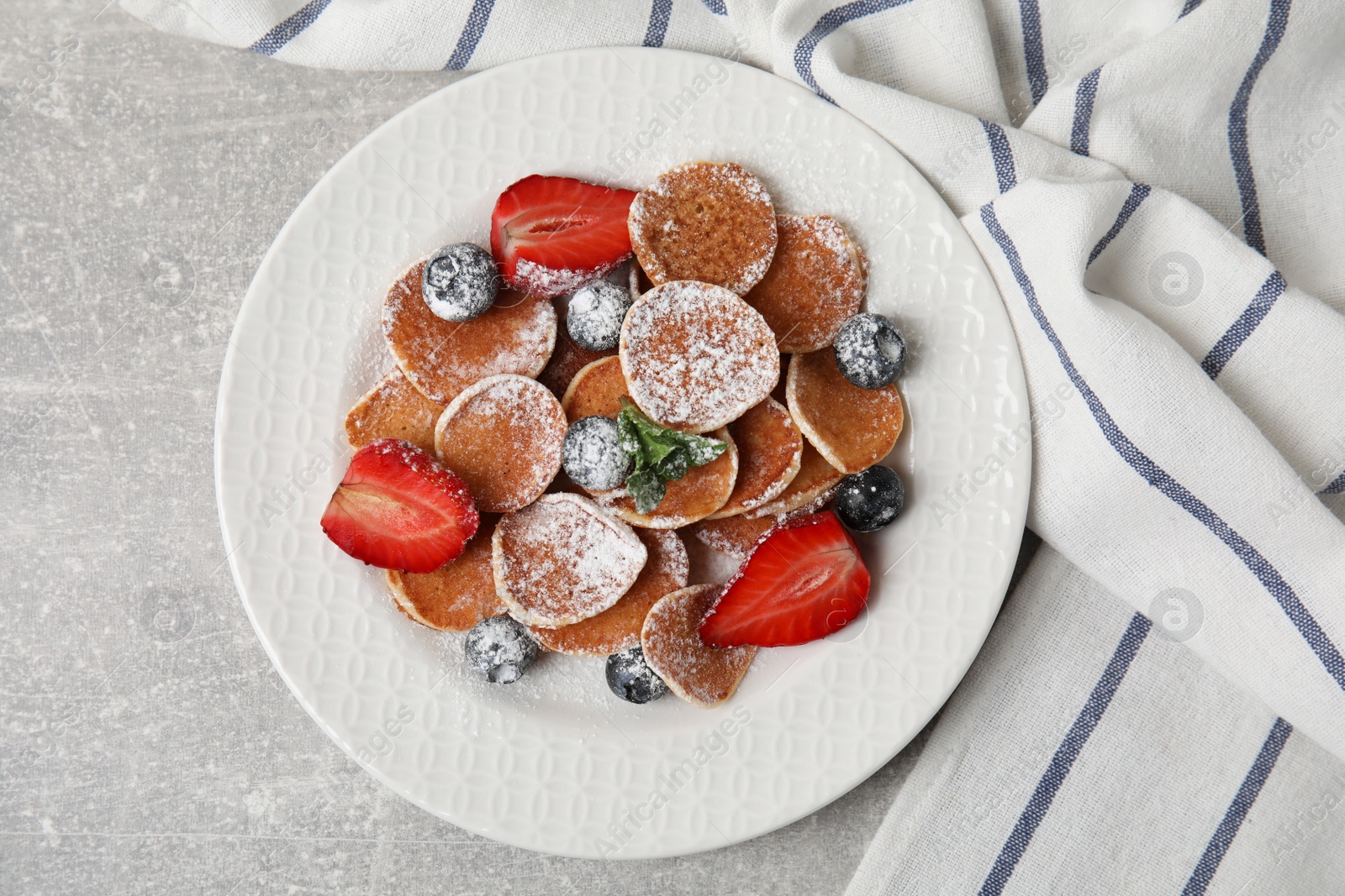 Photo of Cereal pancakes with berries served on light grey table, flat lay