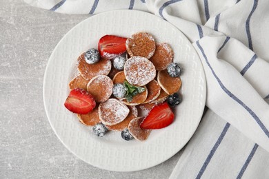 Cereal pancakes with berries served on light grey table, flat lay