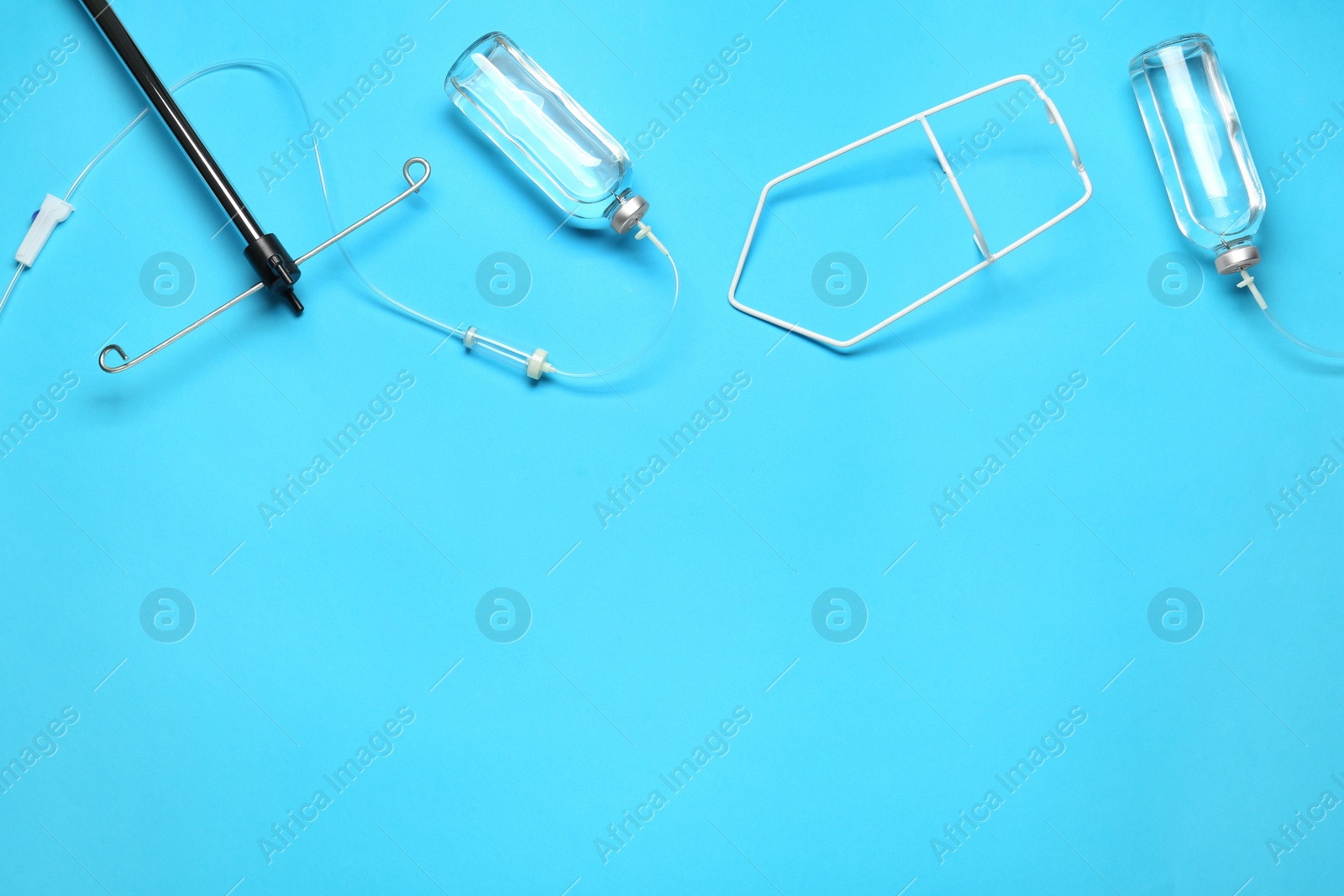 Photo of IV infusion set on light blue background, flat lay. Space for text