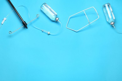 Photo of IV infusion set on light blue background, flat lay. Space for text