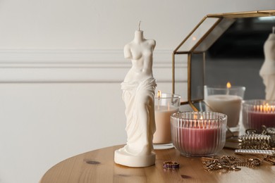Photo of Beautiful Venus De Milo candle on wooden table. Stylish decor
