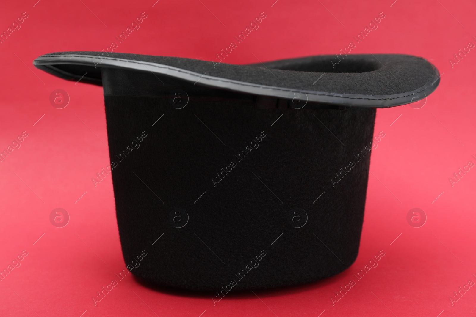 Photo of One magician top hat on red background