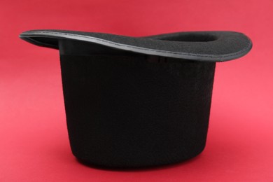 Photo of One magician top hat on red background