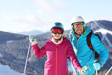 Couple with ski equipment spending winter vacation in mountains