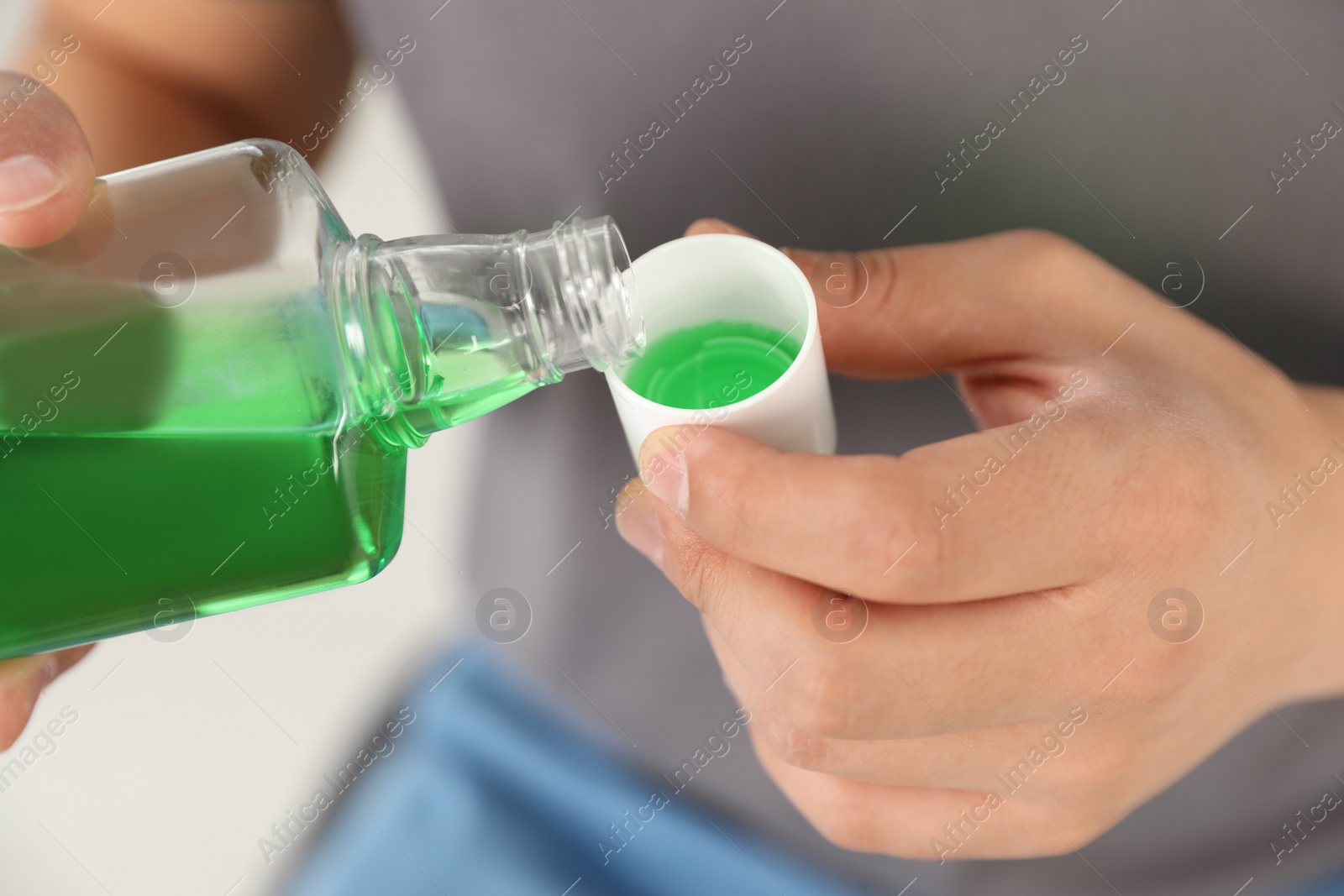 Photo of Man pouring mouthwash from bottle into cap, closeup. Teeth care