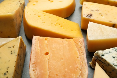 Different kinds of delicious cheese on stone background, closeup