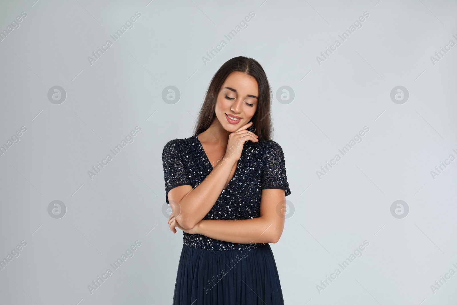 Photo of Young woman wearing stylish dress on light grey background