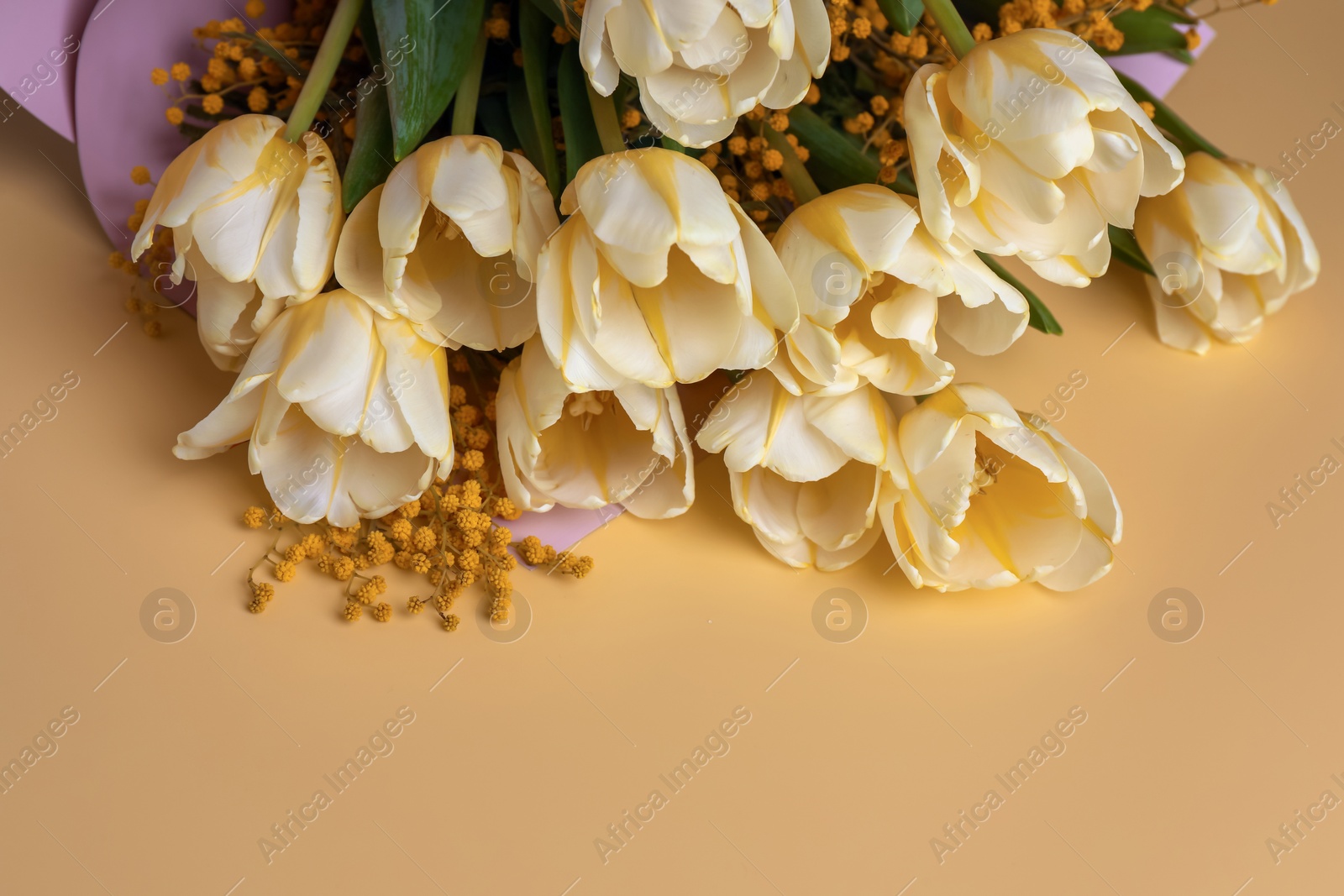 Photo of Bouquet with beautiful tulips and mimosa flowers on yellow background. Space for text