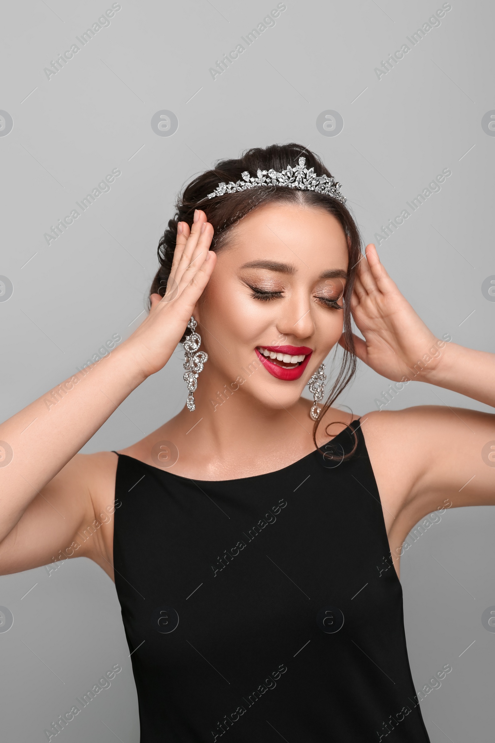 Photo of Beautiful young woman wearing luxurious tiara on light grey background