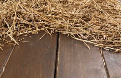 Dried straw on wooden table, space for text