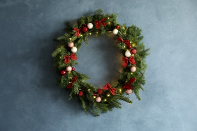 Photo of Beautiful Christmas wreath with festive decor on blue wall