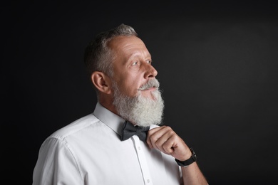 Portrait of handsome senior man on black background