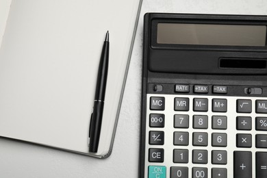 Calculator and office stationery on white table, top view. Space for text