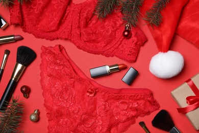 Photo of Christmas gift set with sexy women lingerie on red background, flat lay