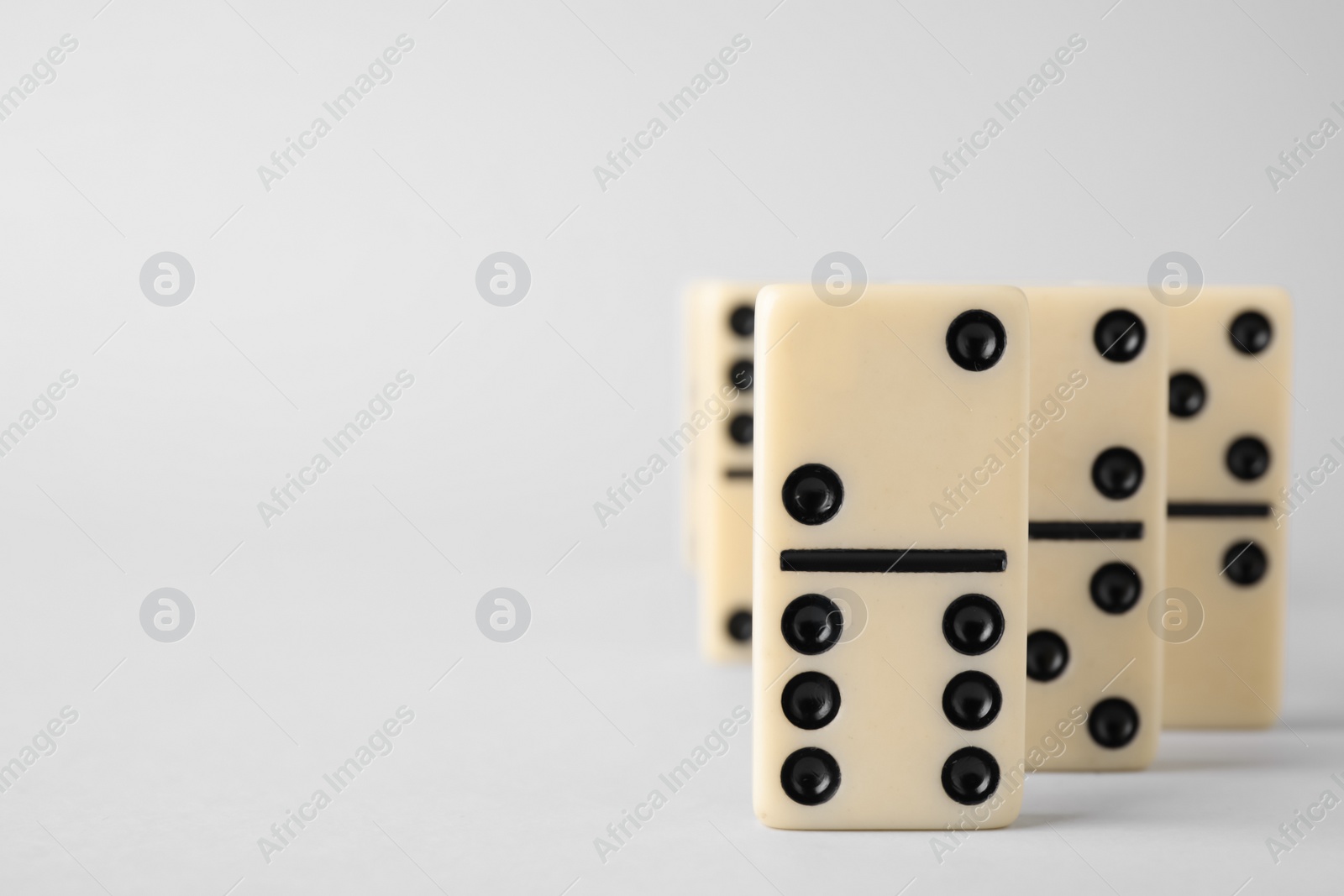 Photo of Domino tiles on white background. Space for text