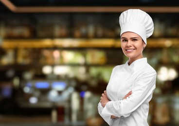 Smiling chef in uniform at restaurant, space for text