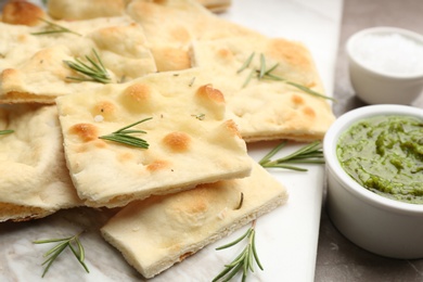 Photo of Delicious focaccia bread on marble board, closeup