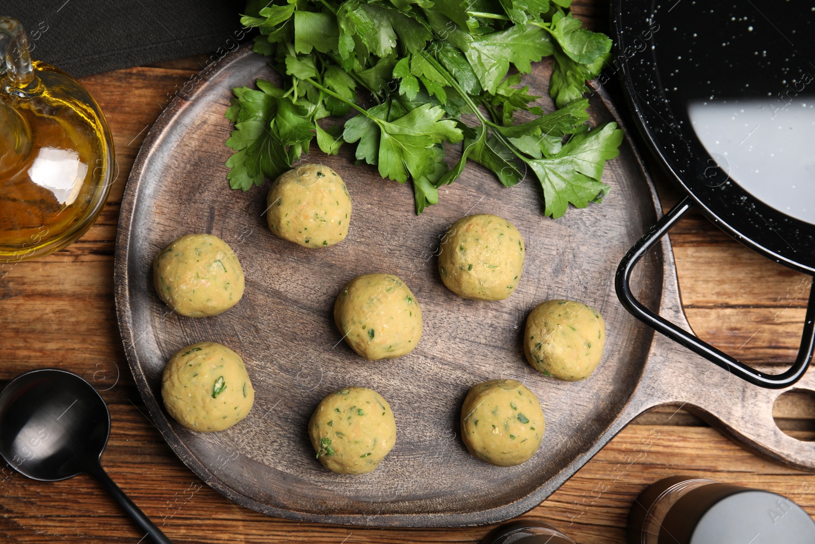 Photo of Raw falafel balls and ingredients on wooden table, flat lay