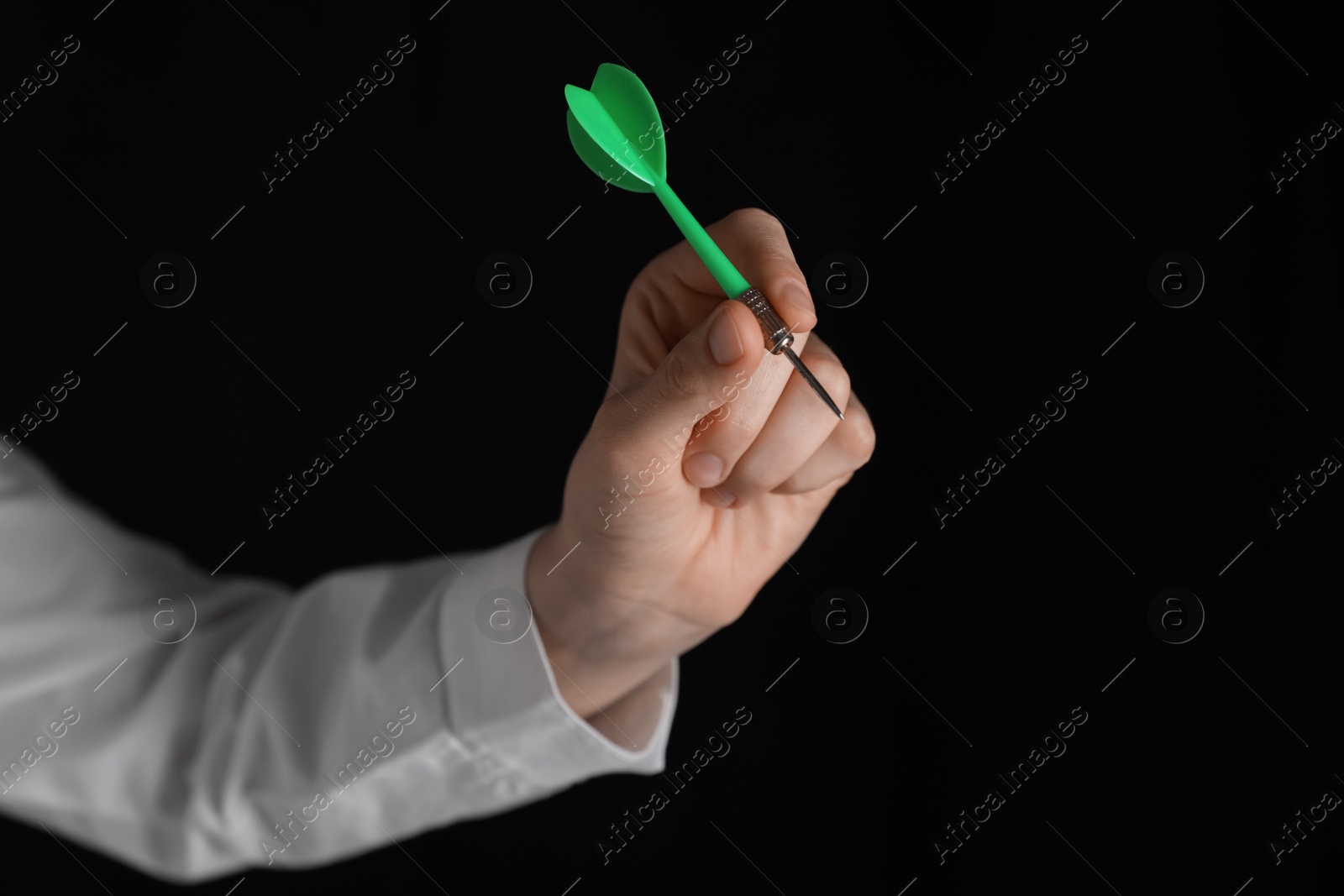 Photo of Businesswoman holding green dart on black background, closeup