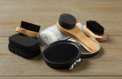 Composition with shoe care accessories on wooden background, closeup