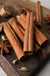 Photo of Board with different aromatic spices on light table, closeup