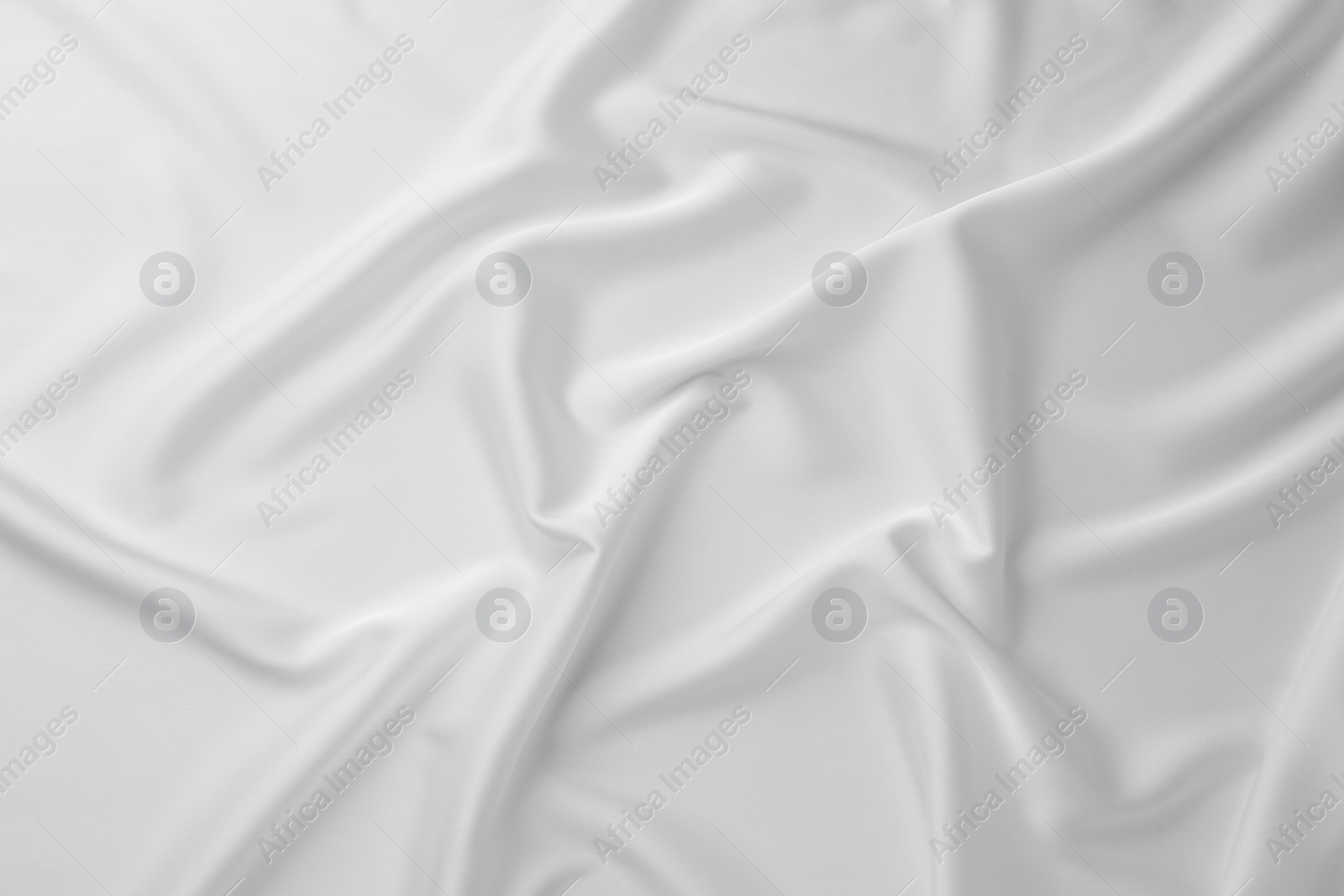 Photo of Texture of crumpled white silk fabric as background, top view