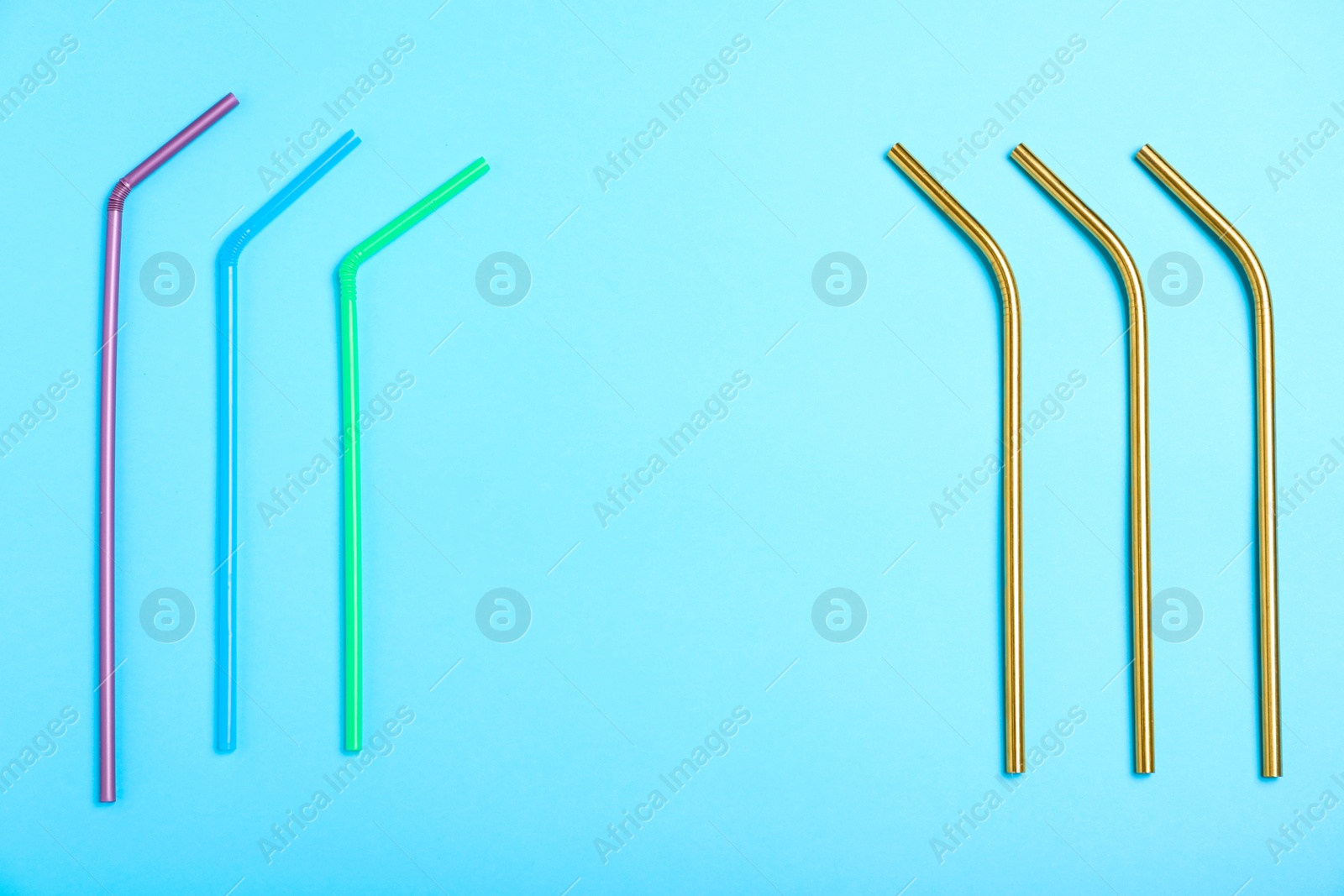 Photo of Flat lay composition with plastic and metal drinking straws on light blue background, space for text. Recycling concept