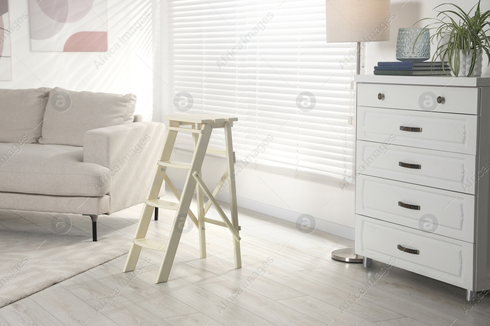 Photo of Folding ladder on wooden floor at home