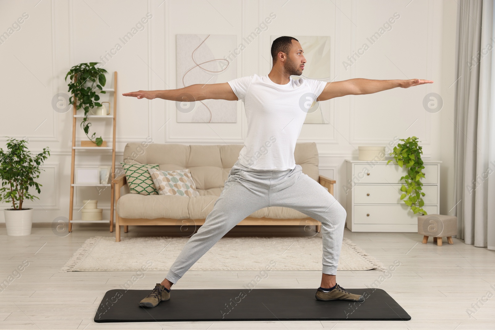 Photo of Man doing morning exercise on fitness mat at home