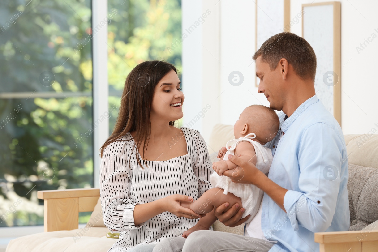 Photo of Portrait of happy family with their cute baby at home