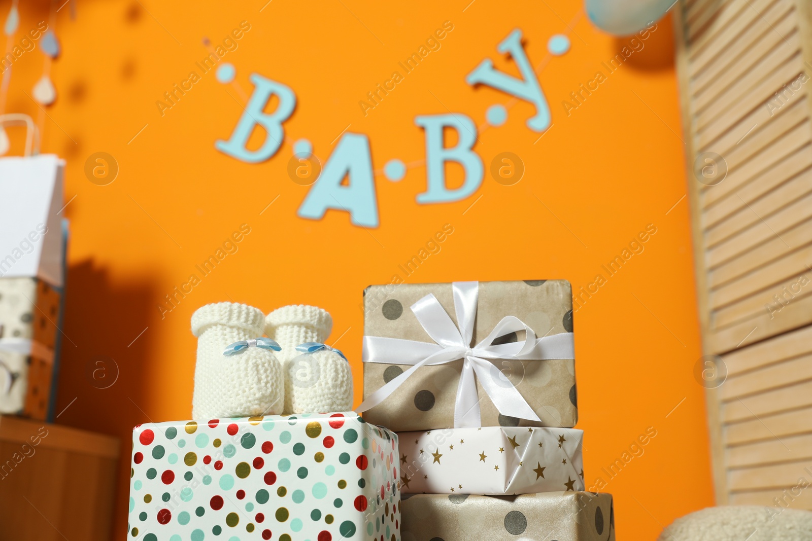 Photo of Baby shower party. Festive decor, booties and gift boxes indoors