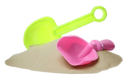 Photo of Pile of sand and colorful plastic toy shovels on white background