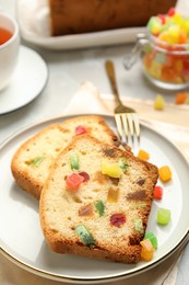 Photo of Delicious cake with candied fruits on plate, closeup
