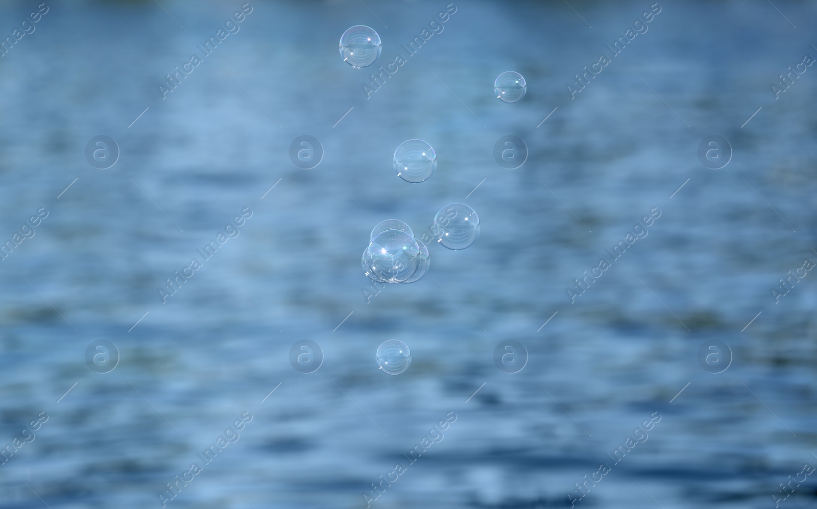 Photo of Beautiful translucent soap bubbles outdoors on sunny day. Space for text
