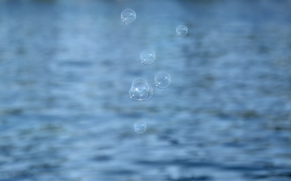 Beautiful translucent soap bubbles outdoors on sunny day. Space for text