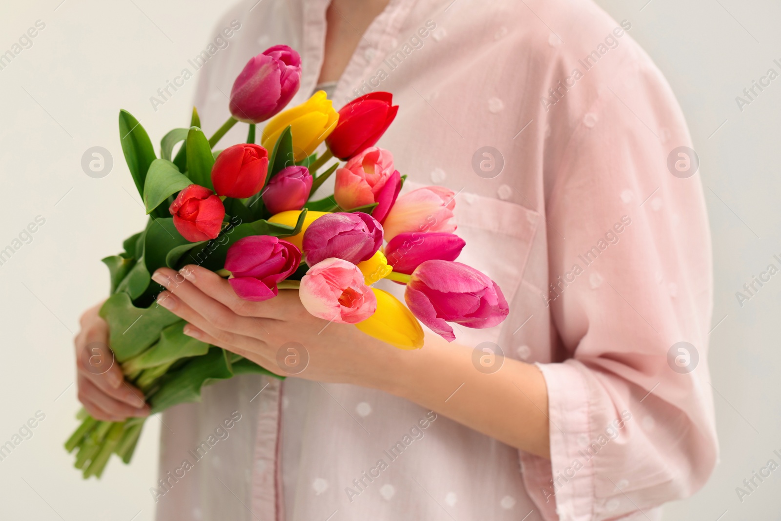 Photo of Woman holding beautiful colorful tulip flowers on white background, closeup