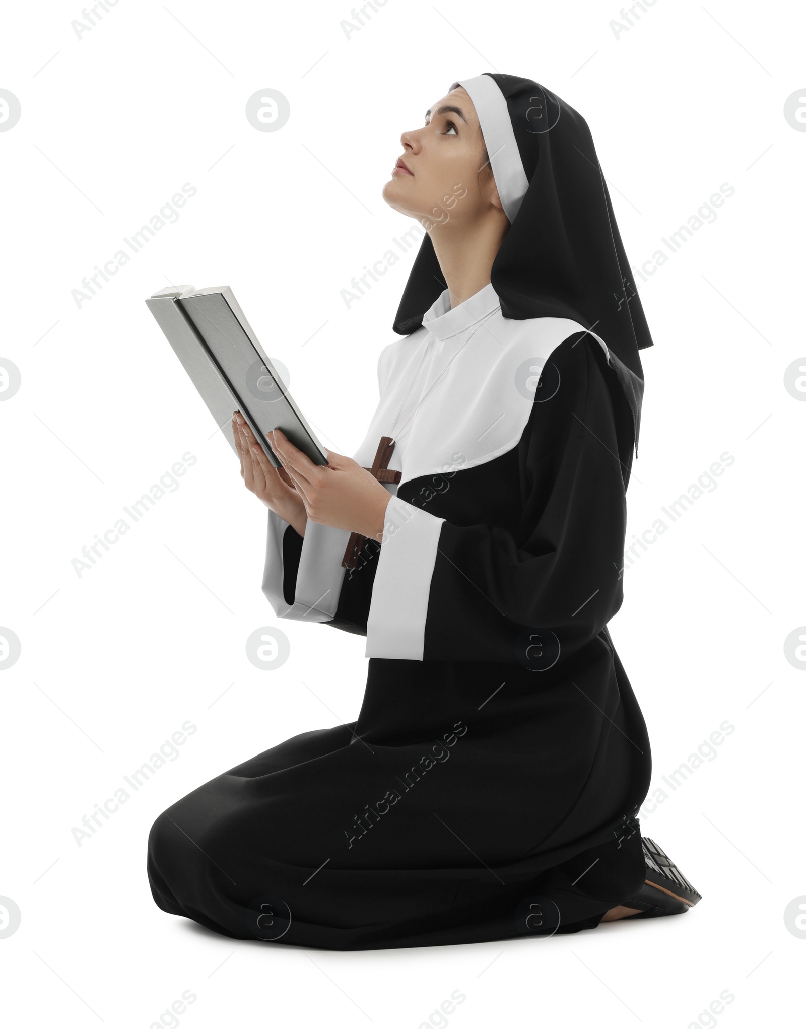 Photo of Young nun with Bible praying to God on white background