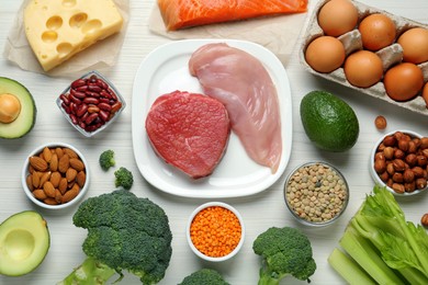 Different fresh products on white wooden table, flat lay. Sources of essential amino acids