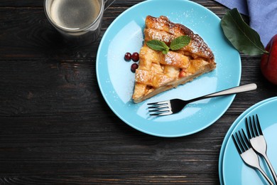 Slice of traditional apple pie on black wooden table, flat lay. Space for text