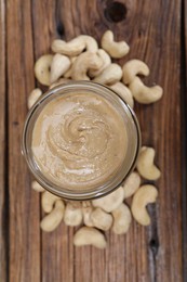 Photo of Tasty cashew nut paste in jar on wooden table, top view