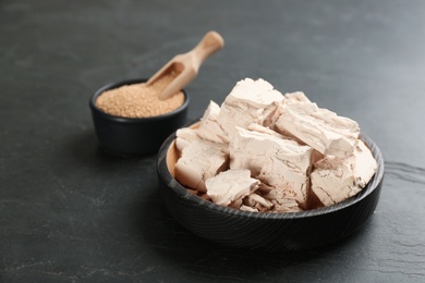 Photo of Compressed and granulated yeast on black table