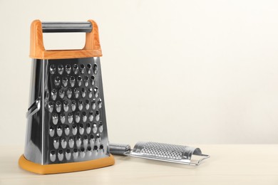 Photo of Modern graters on white wooden table. Space for text