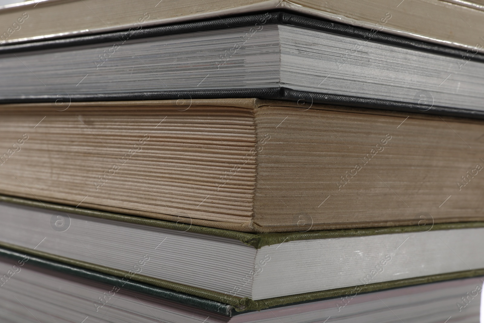 Photo of Stack of many different hardcover books as background, closeup